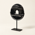 Black natural stone disk on metal stand, angled view