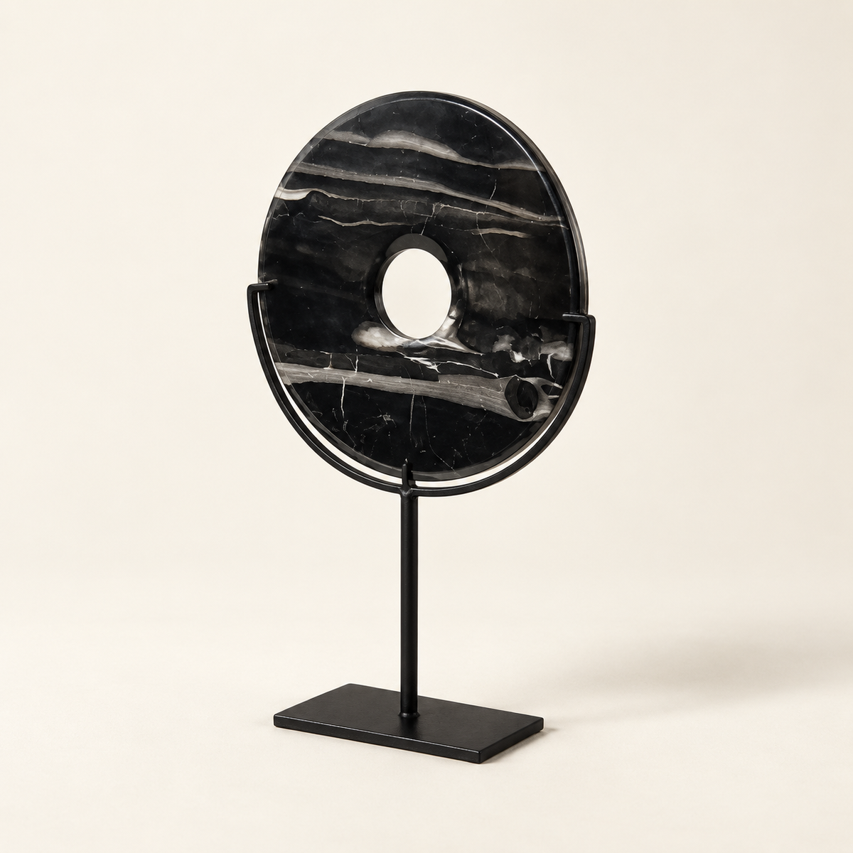 Black natural stone disk on metal stand, angled view