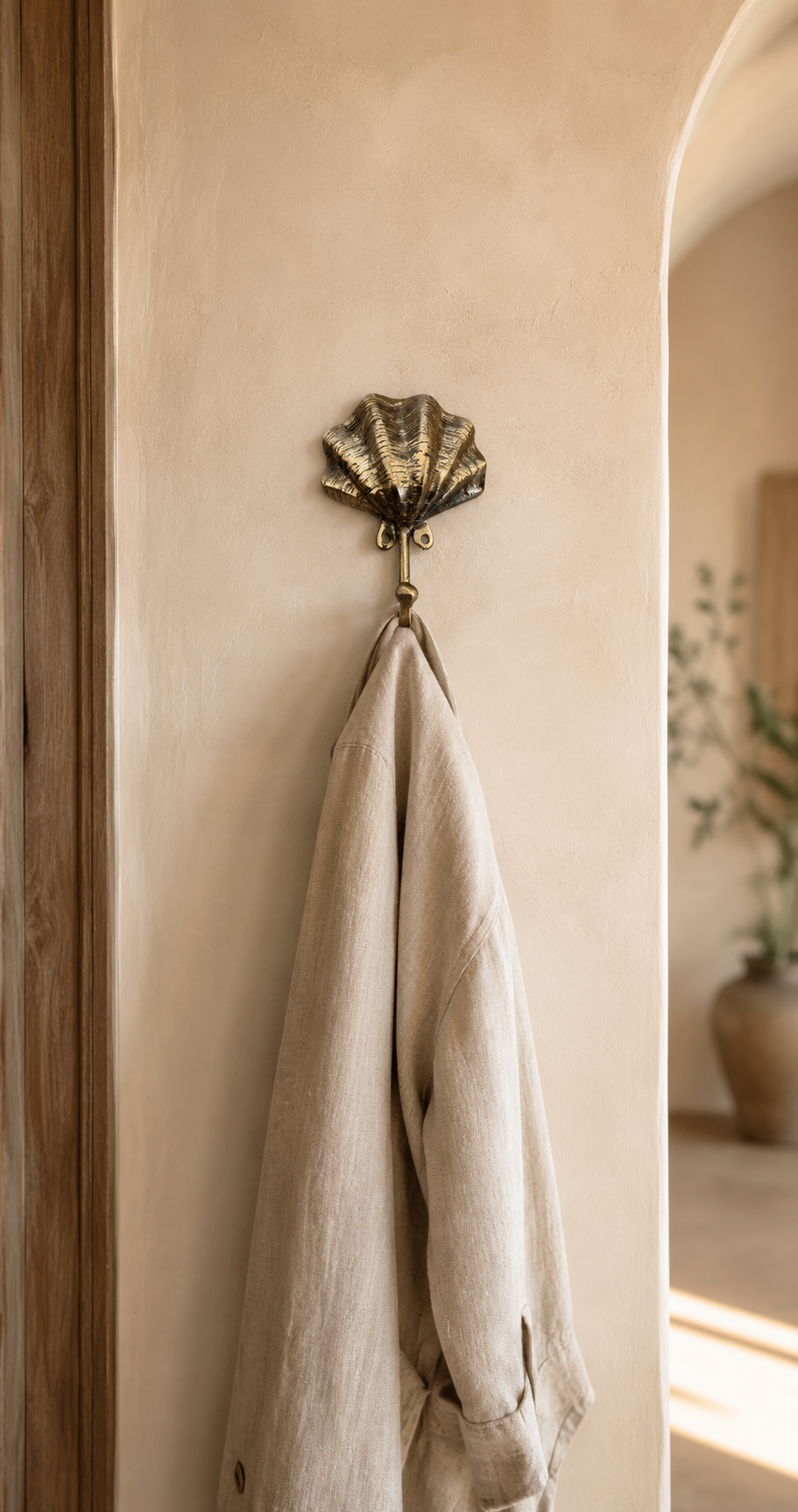Bronze scallop shell wall hook in a coastal bathroom