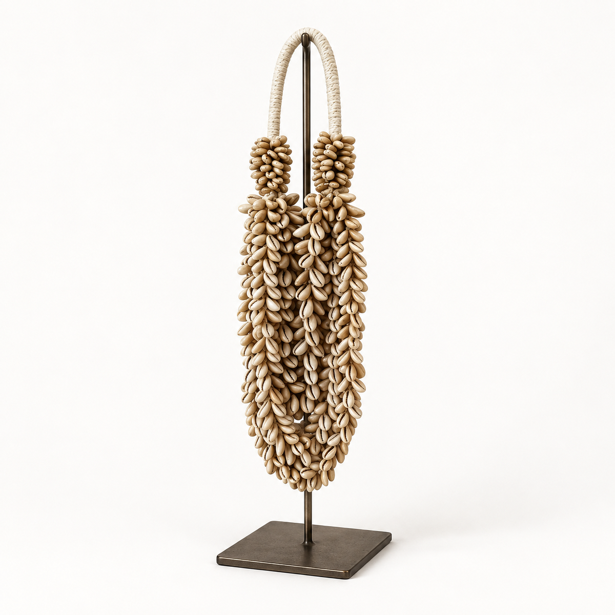 Cowrie decorative shell necklace — Cowrie shell necklace on metal stand, three-quarter catalog view