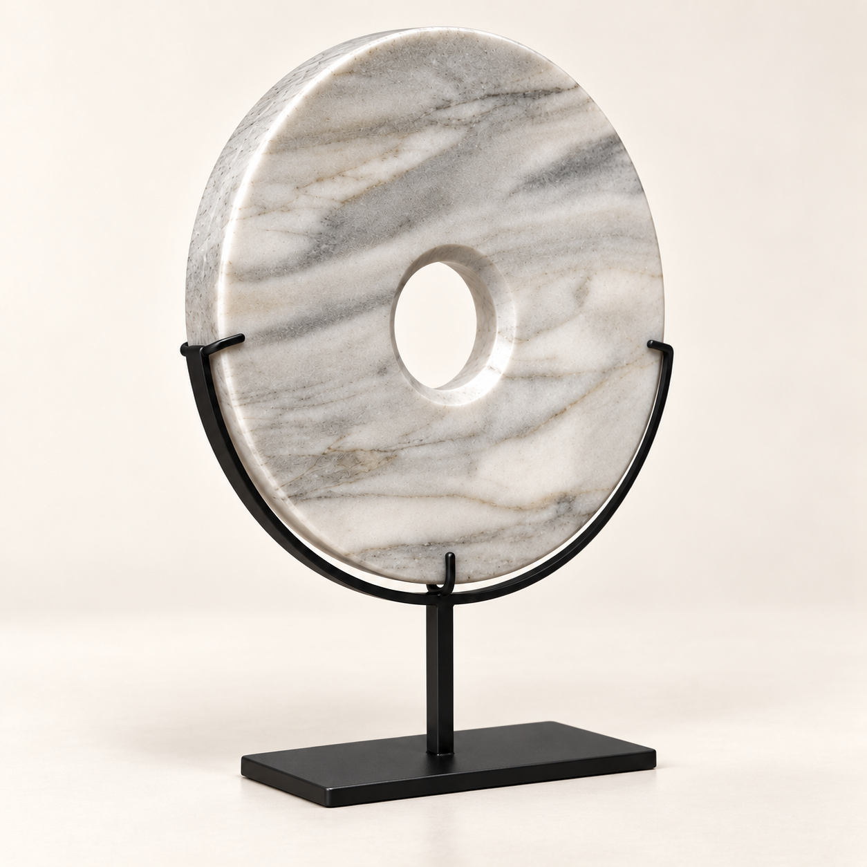 White natural stone disk sculpture showing natural veining