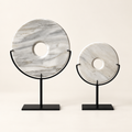 Two white natural stone disk sculptures on black metal stands